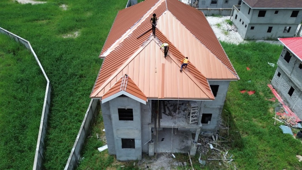 Persaud's crew installing copper standing seam panels on a residential roof